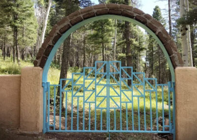The finished steel garden gate with adobe brick arch.